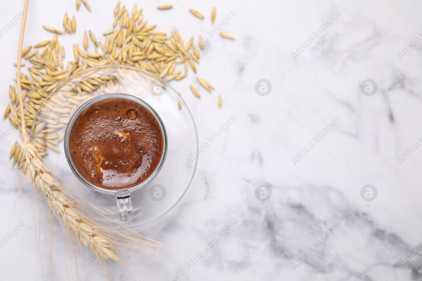 Photo of Cup of barley coffee, grains and spike on light table, flat lay. Space for text