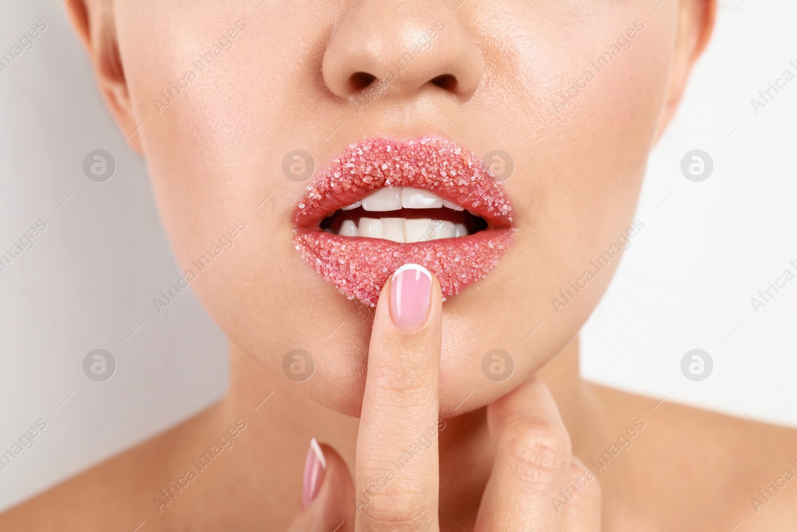 Photo of Young woman with sugar lips on white background, closeup