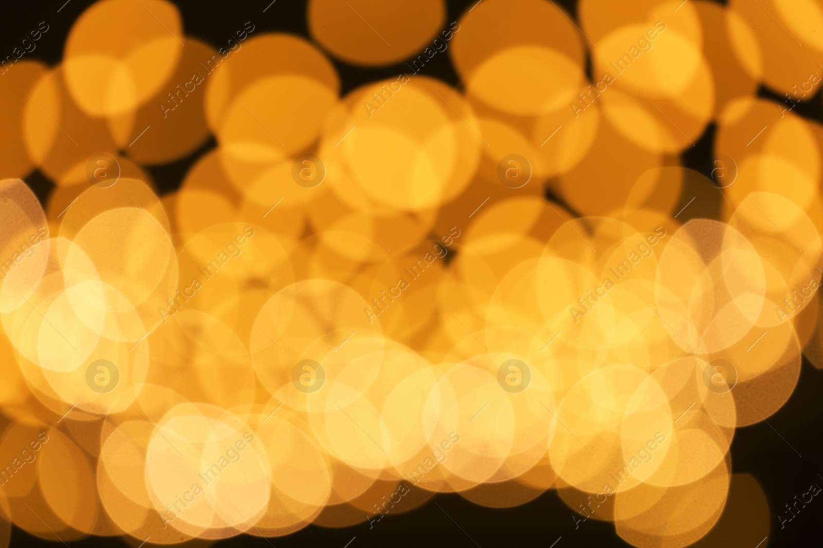 Photo of Beautiful golden lights on dark background. Bokeh effect