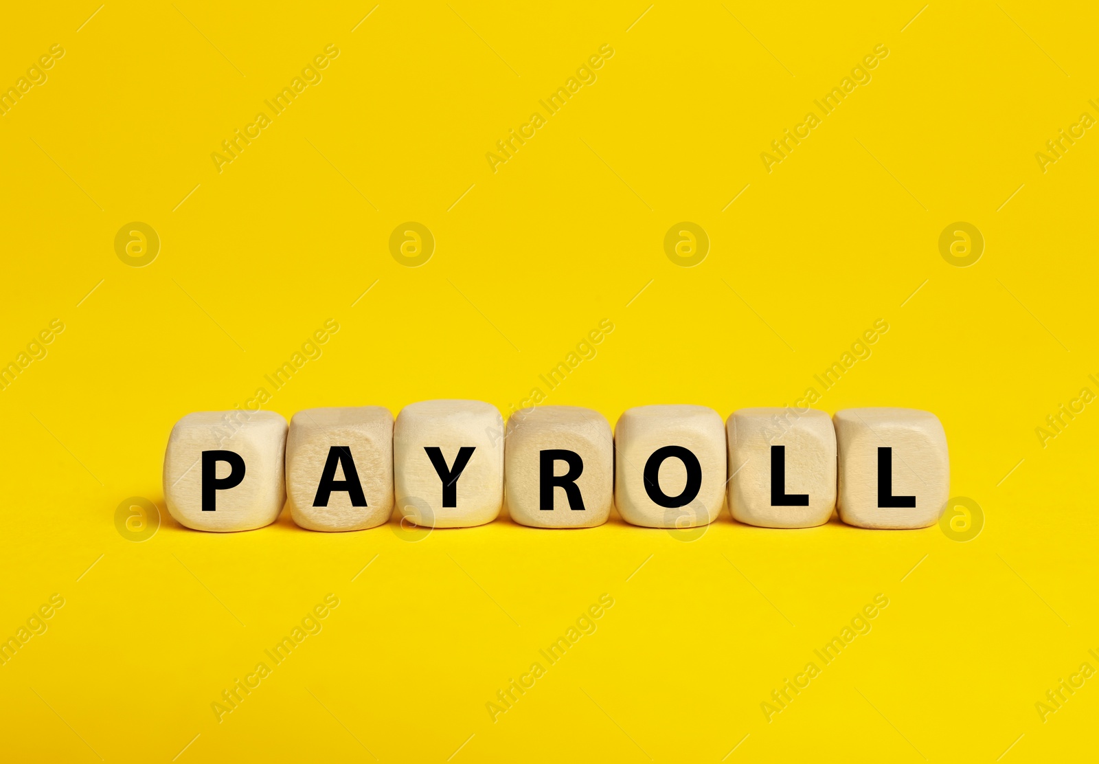 Photo of Cubes with word Payroll on yellow background