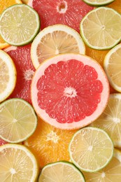 Photo of Different sliced citrus fruits as background, top view