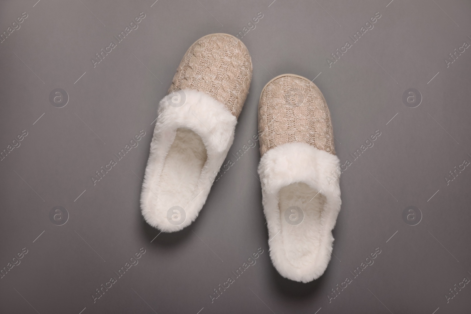 Photo of Pair of beautiful soft slippers on grey background, top view