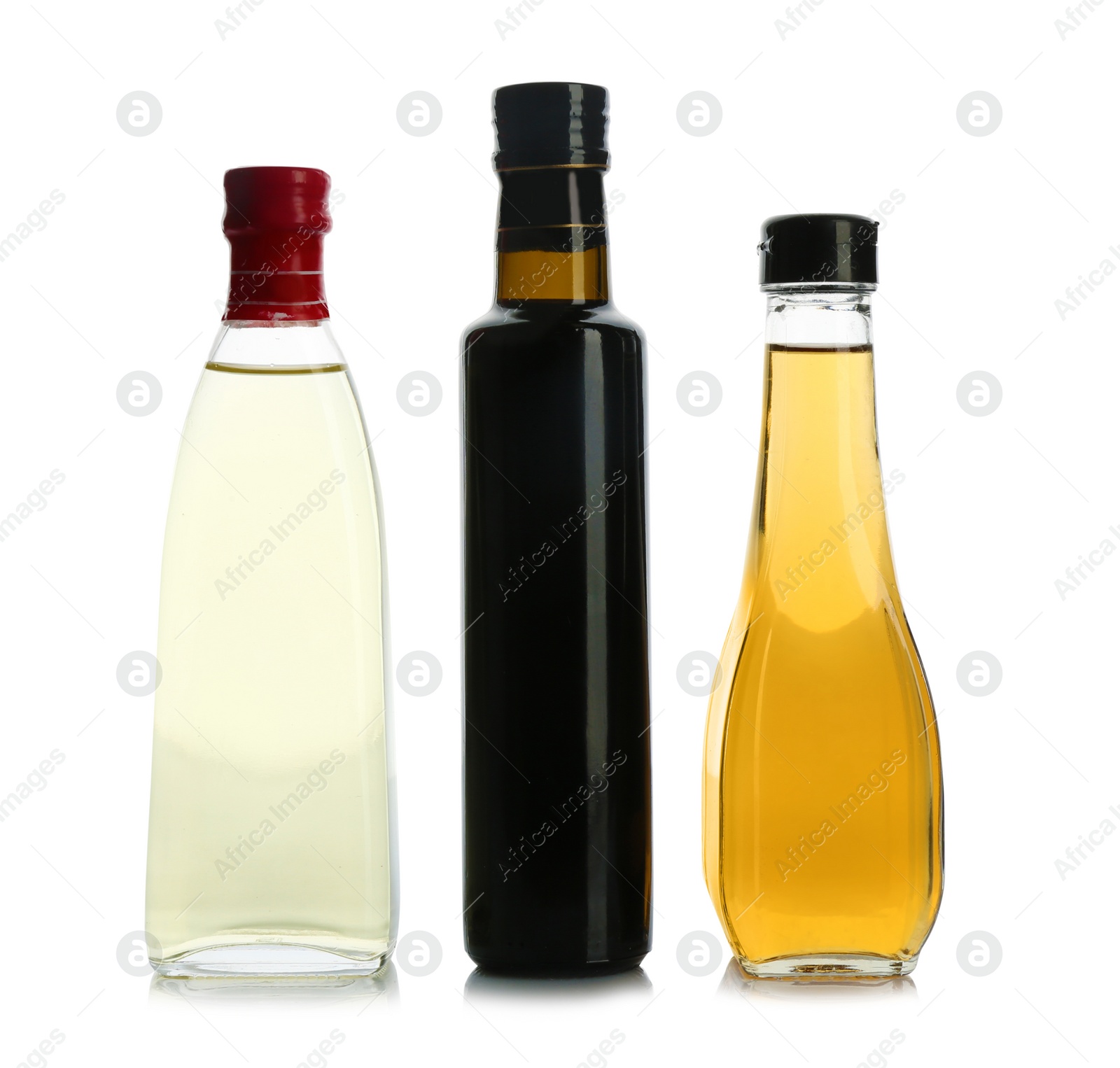 Photo of Glass bottles with different kinds of vinegar on white background