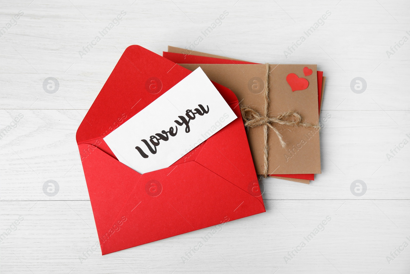 Photo of Love letter and stack of envelopes on white wooden background, flat lay