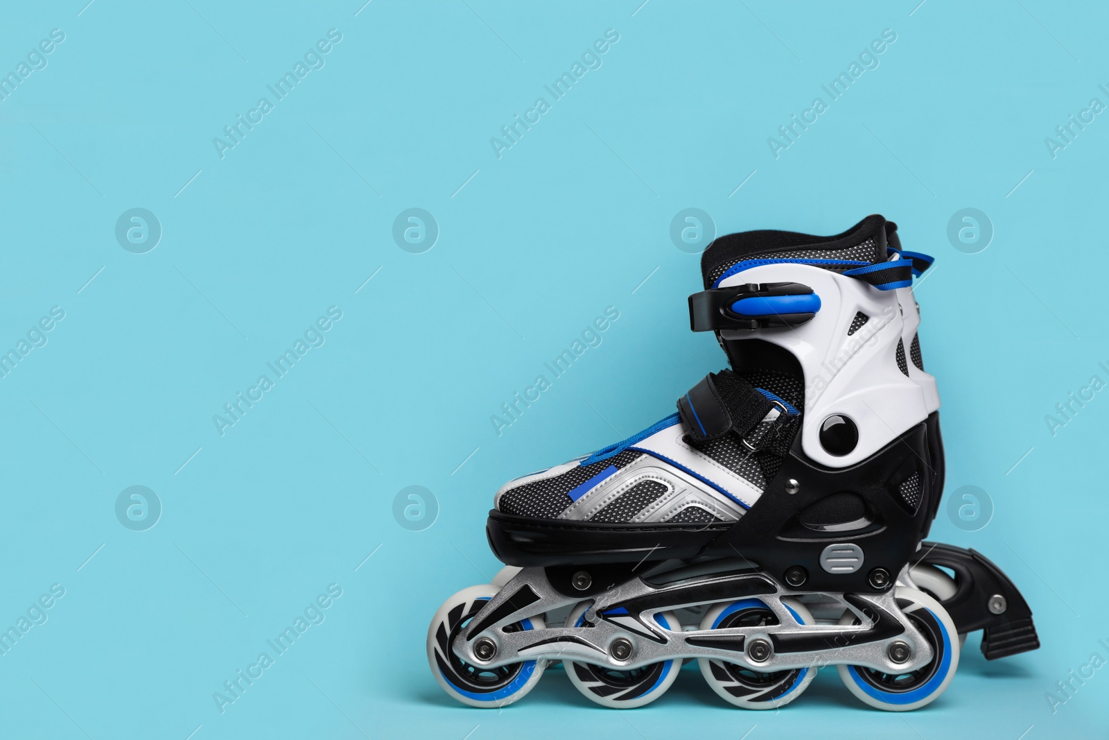Photo of Pair of inline roller skates on color background. Space for text