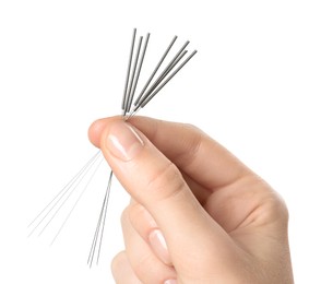 Woman holding needles for acupuncture on white background, closeup