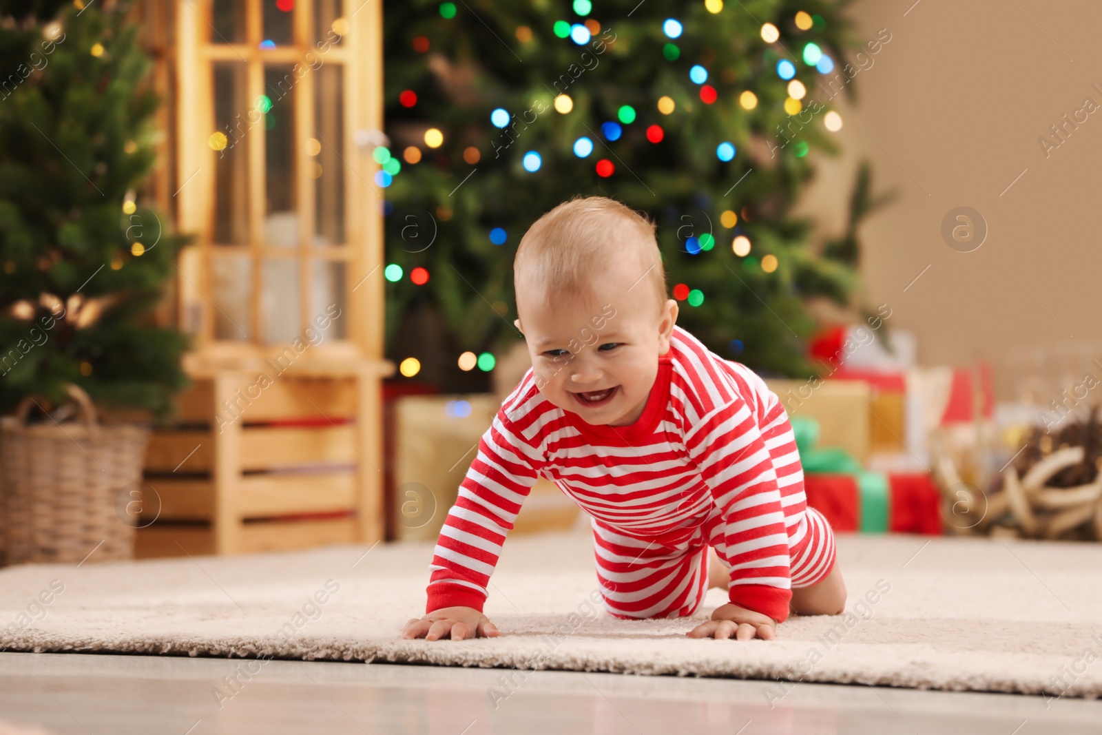 Photo of Cute little baby in room decorated for Christmas. Winter holiday