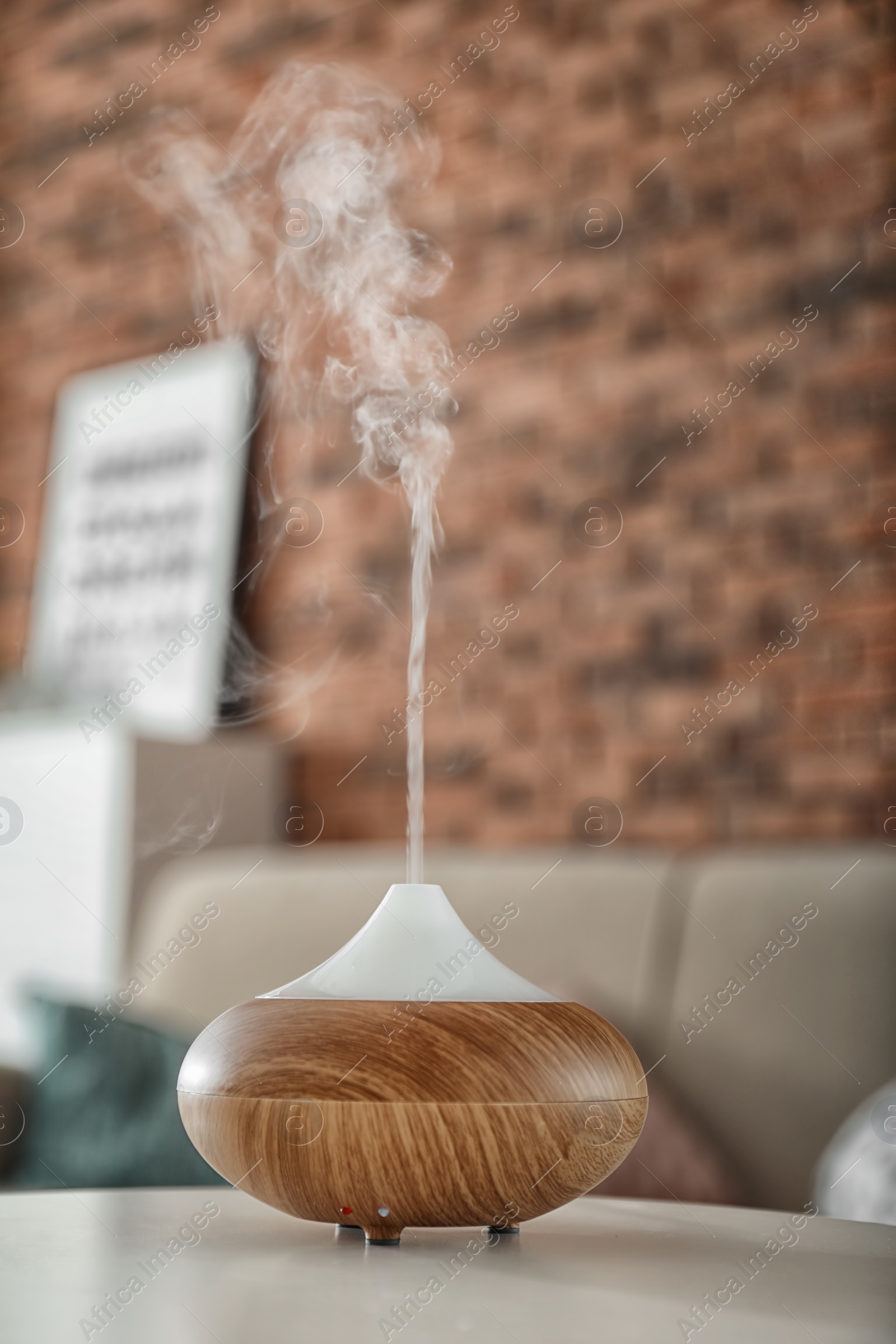 Photo of Aroma oil diffuser on table at home. Air freshener