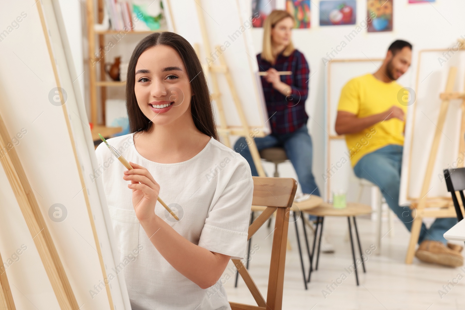 Photo of Group of students attending painting class in studio. Creative hobby