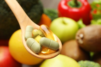 Photo of Dietary supplements. Spoon with different pills over food products, closeup. Space for text