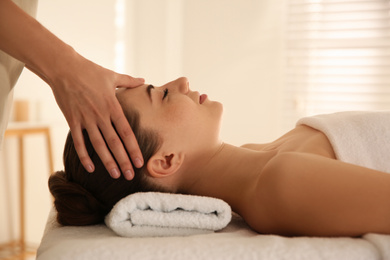 Photo of Young woman receiving head massage in spa salon