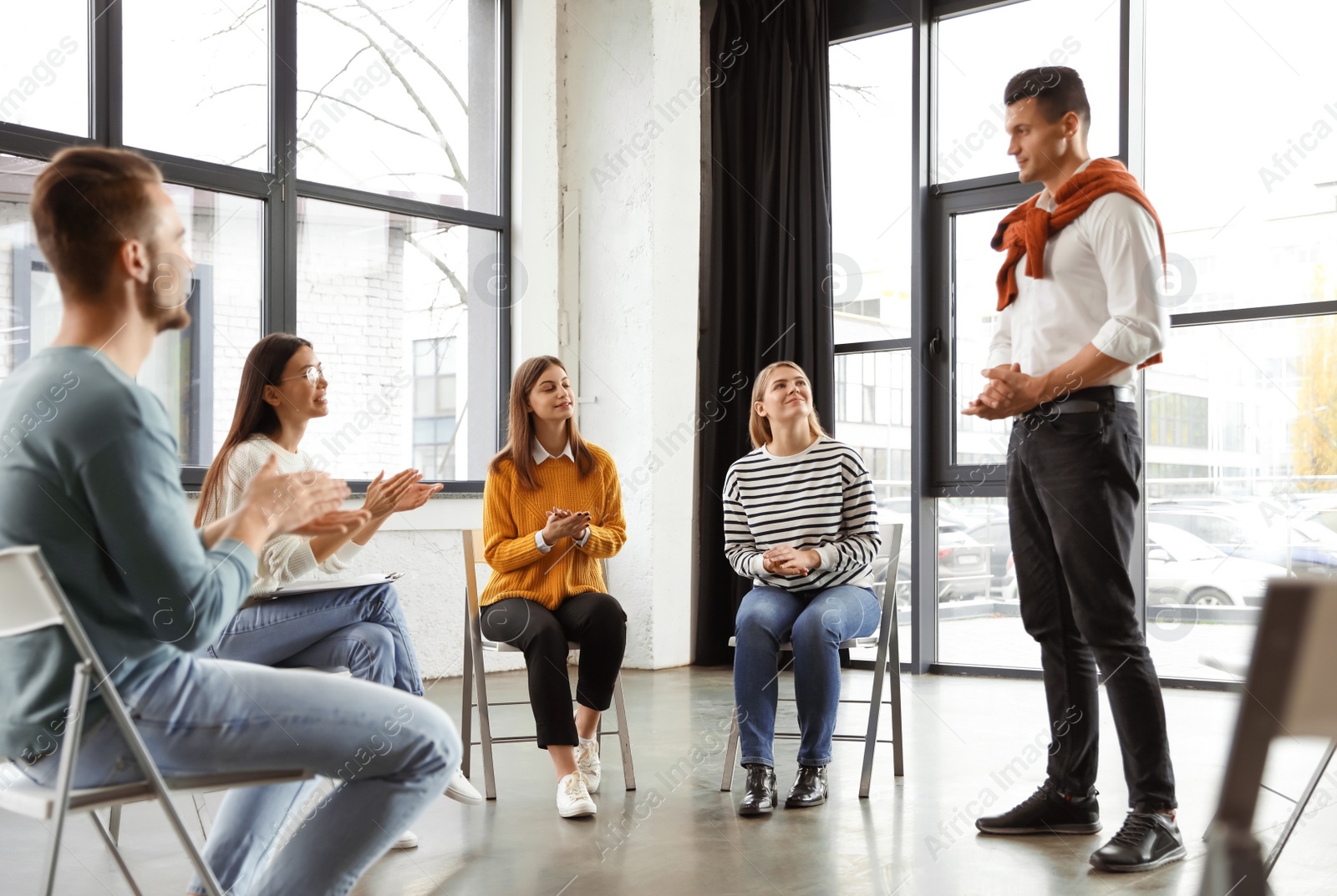 Photo of Psychotherapist working with patients in group therapy session indoors