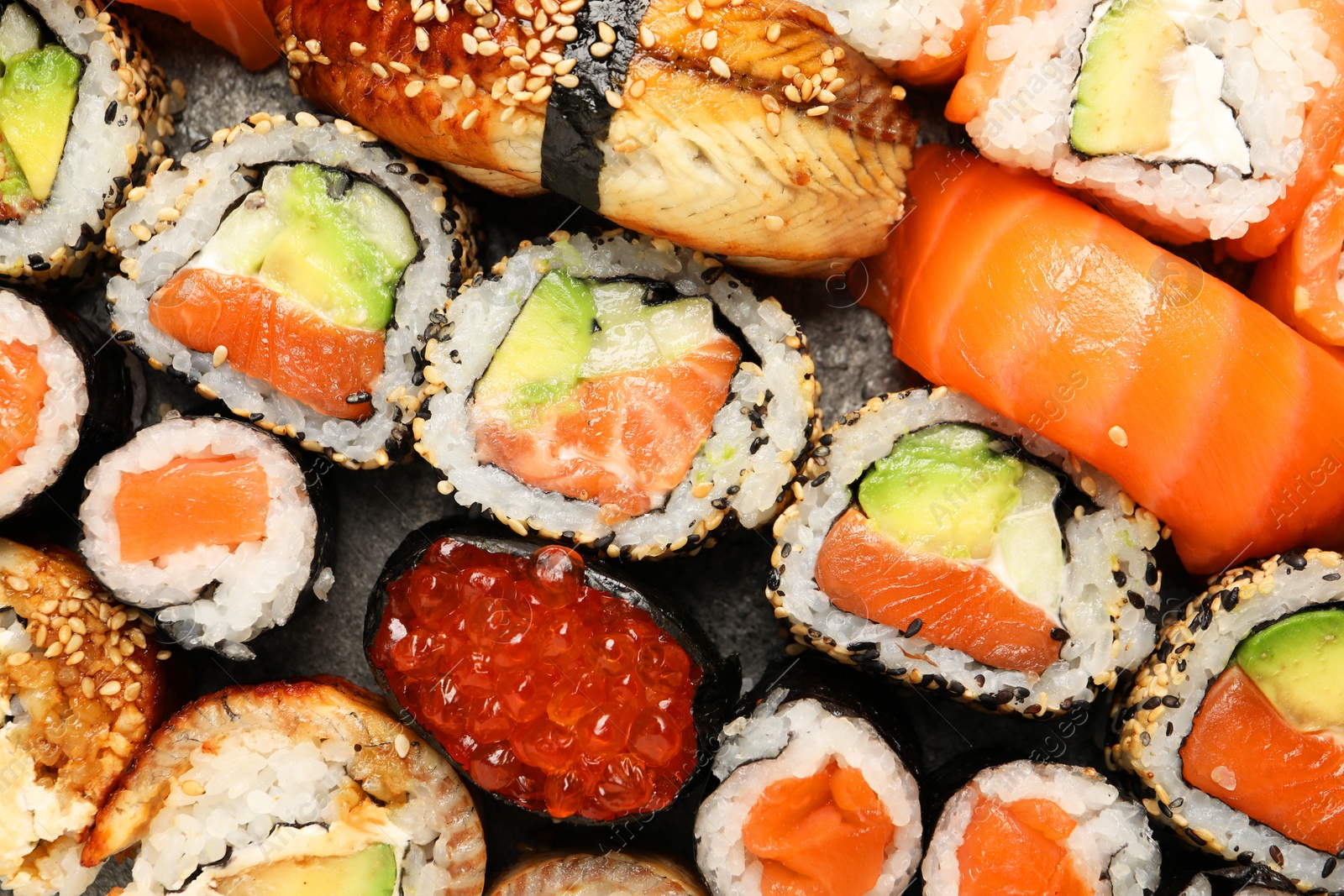 Photo of Different tasty sushi rolls as background, top view