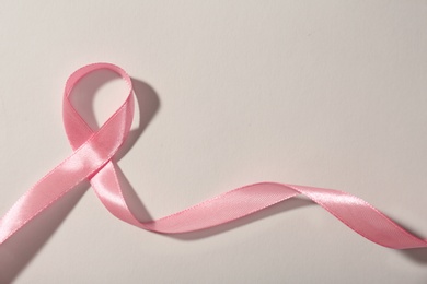 Photo of Pink ribbon and space for text on gray background. Breast cancer awareness concept