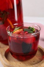 Photo of Glass of delicious refreshing sangria on tray, closeup