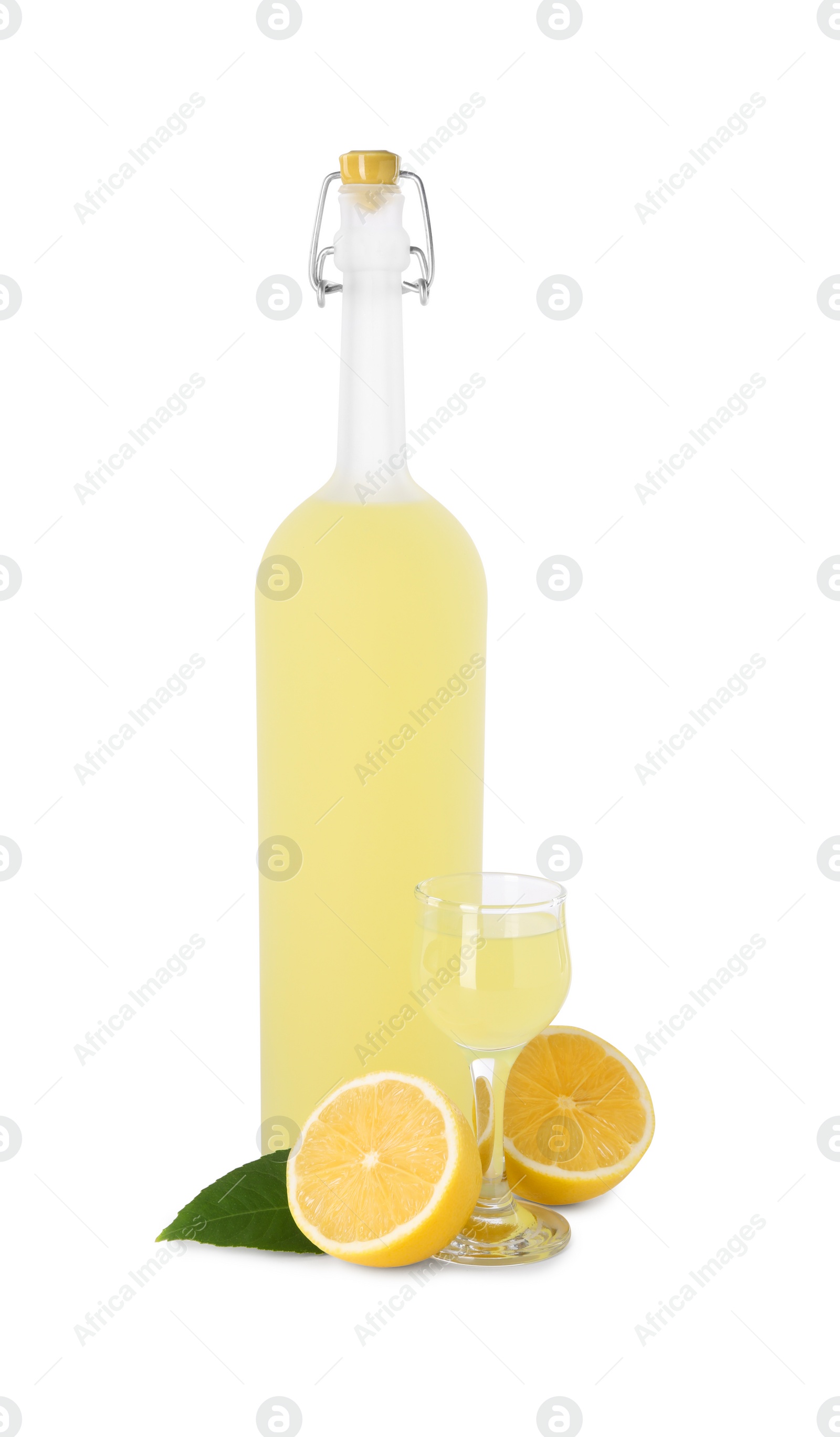 Photo of Tasty limoncello liqueur, halves of lemon and green leaf isolated on white