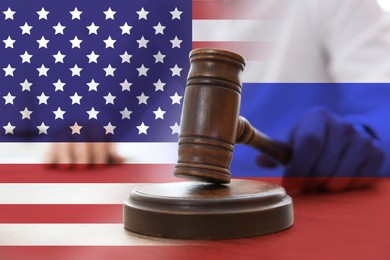 Image of Economic sanctions against Russia because of invasion in Ukraine. Judge with gavel at table, American and Russian flags. Multiple exposure