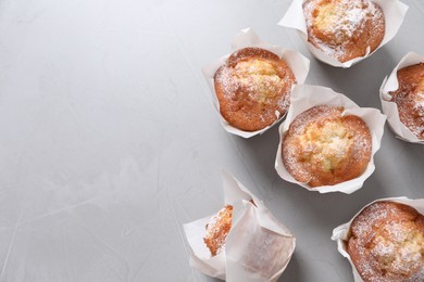 Photo of Delicious muffins on grey table, flat lay. Space for text