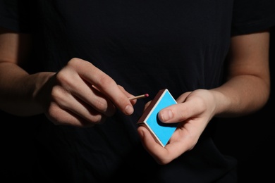 Woman with box of matches, closeup of hands