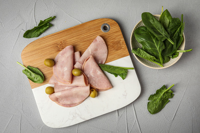 Photo of Ham with olives and spinach on light grey table, flat lay