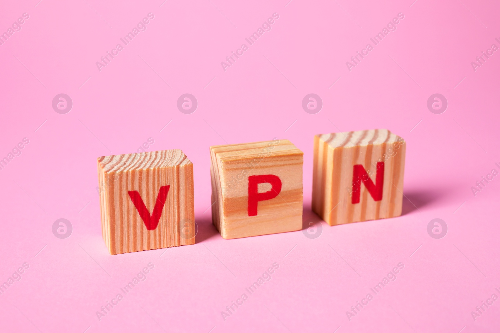 Photo of Wooden cubes with acronym VPN on pale pink background