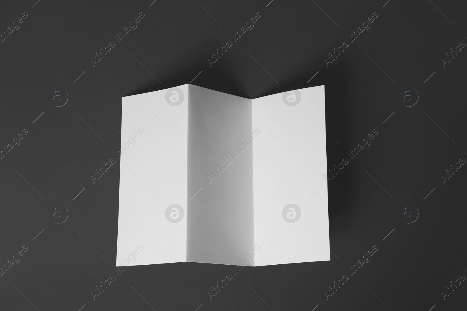 Photo of Blank brochure on dark grey background, top view. Mock up for design