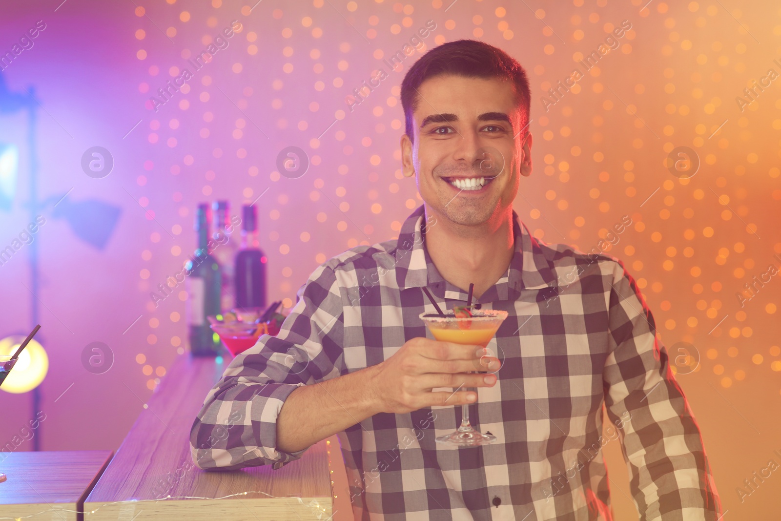 Photo of Young man with glass of martini cocktail at party