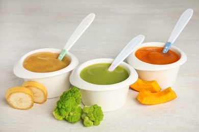 Photo of Bowls with different baby food on light table