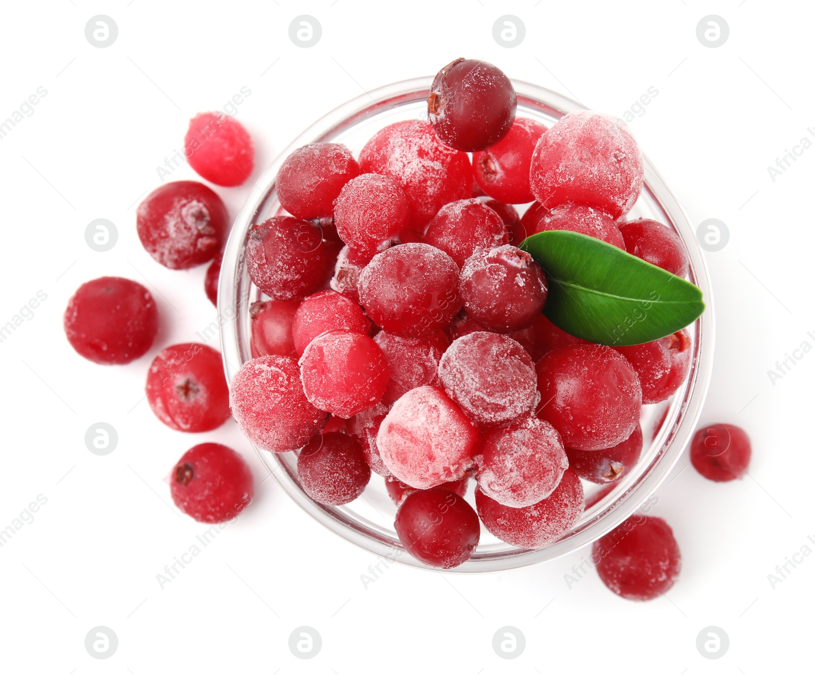 Photo of Frozen red cranberries in bowl and green leaf isolated on white, top view