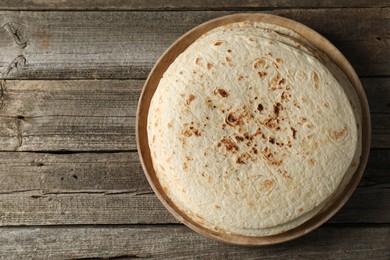 Photo of Stack of tasty homemade tortillas on wooden table, top view. Space for text