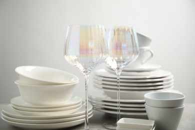 Photo of Set of clean dishes and glasses on table