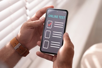 Man using smartphone for online test indoors, closeup