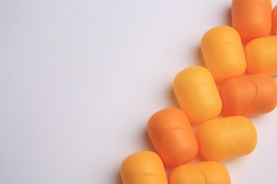 Sveti Vlas, Bulgaria - June 30, , 2023: Orange plastic capsules from Kinder Surprise Eggs on white background, flat lay and space for text