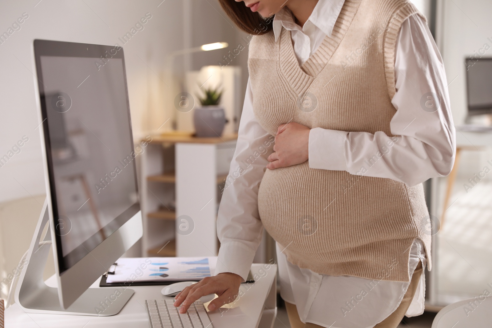 Photo of Pregnant woman working at home, closeup. Maternity leave