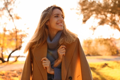 Photo of Beautiful young woman wearing stylish clothes in autumn park