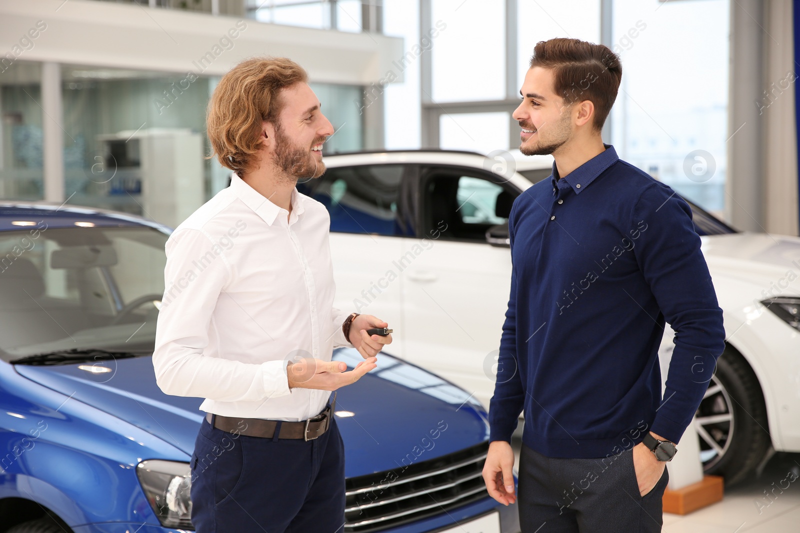 Photo of Car salesman working with customer in dealership