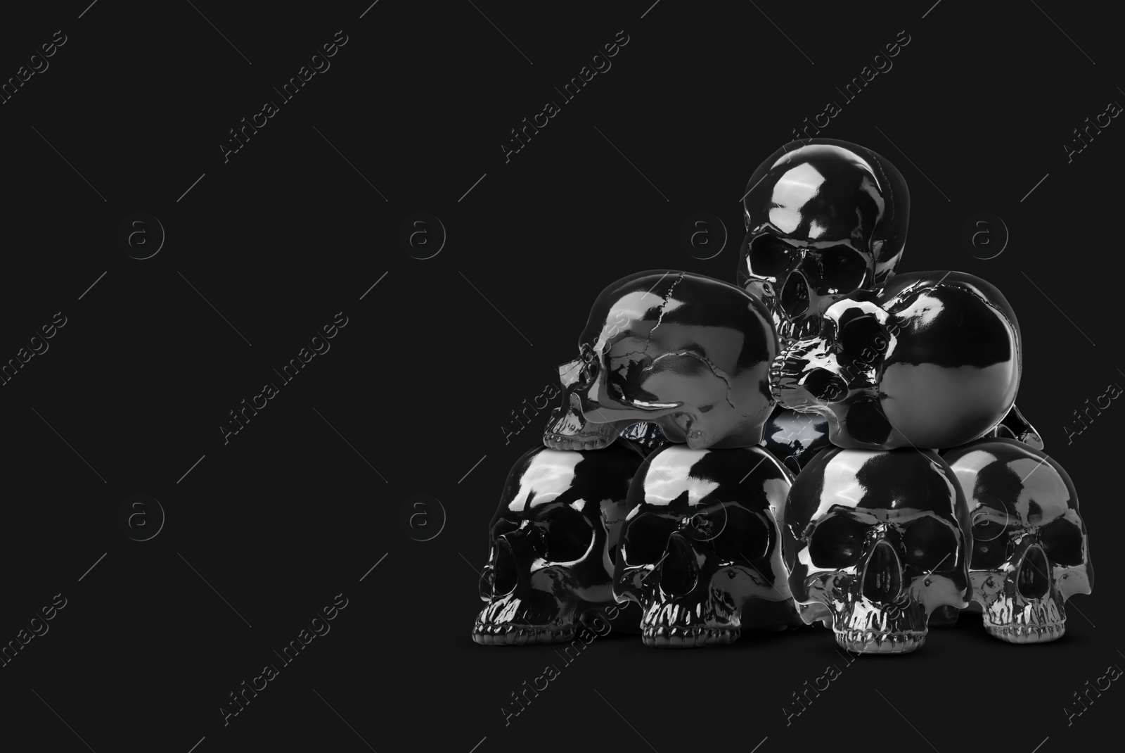 Image of Pile of shiny human skulls on black background, space for text