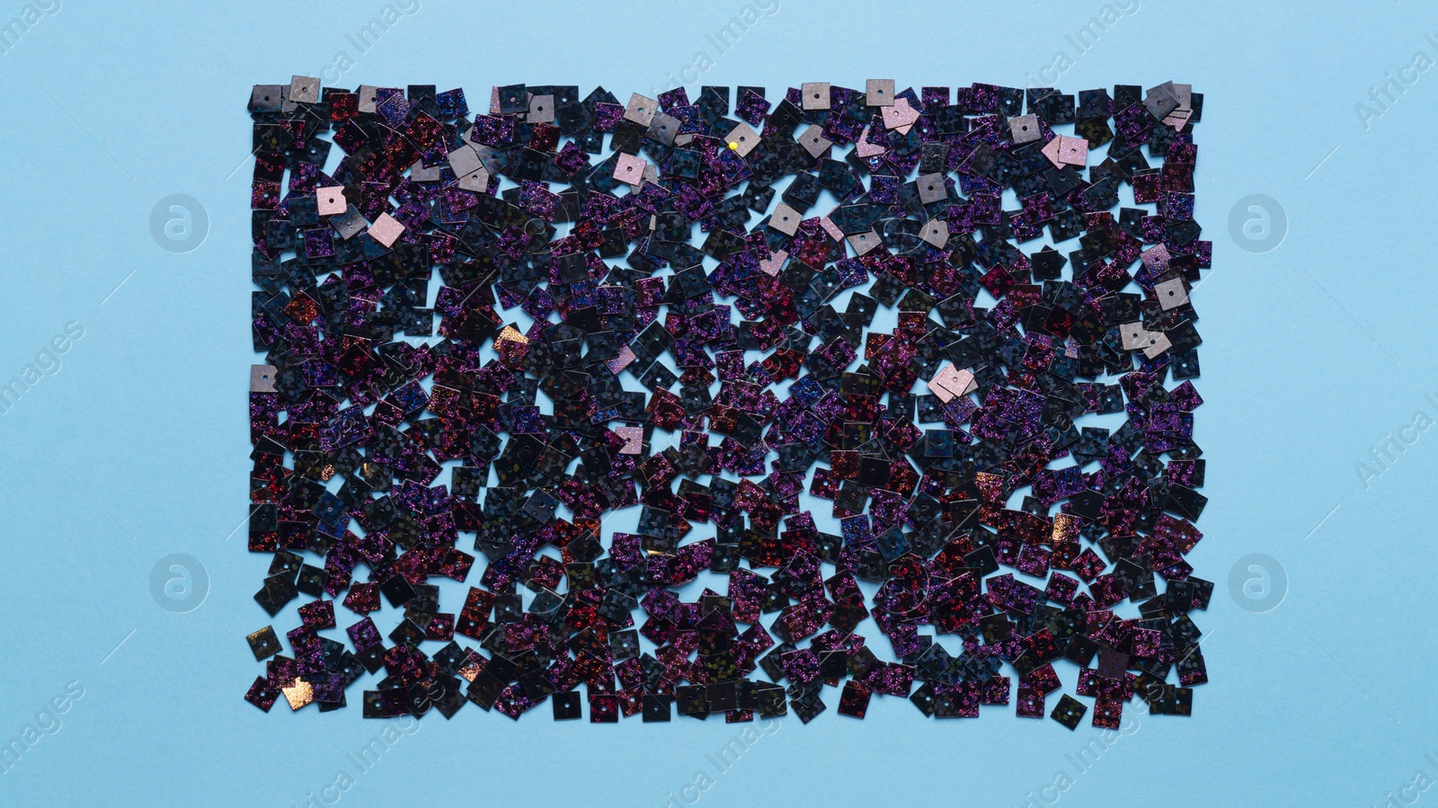 Photo of Beautiful sequins on light blue background, flat lay