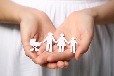 Woman holding paper family figures, closeup. Insurance concept