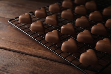 Photo of Beautiful heart shaped chocolate candies on wooden table