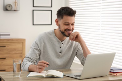 Photo of Man studying on laptop at home. Online translation course