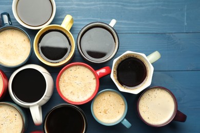 Photo of Many cups of different coffee drinks on blue wooden table, flat lay