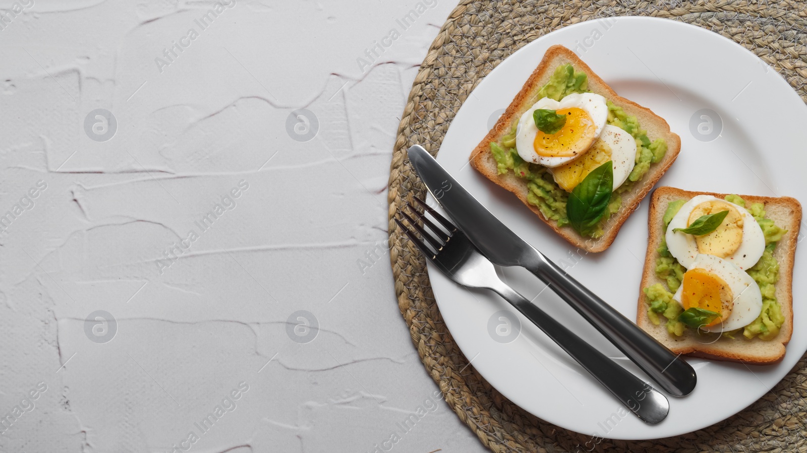 Photo of Tasty sandwiches with boiled egg, avocado and spinach served on white textured table, top view. Space for text