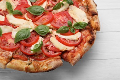 Photo of Delicious Caprese pizza on white wooden table, closeup