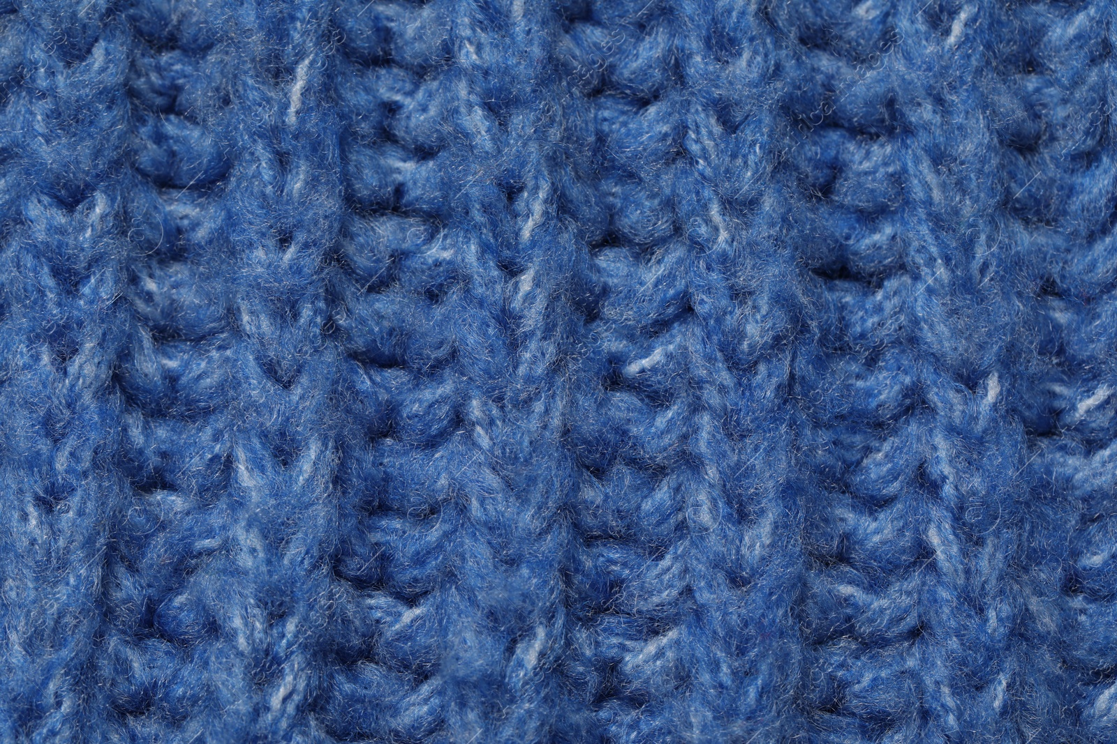 Photo of Texture of soft blue knitted fabric as background, closeup