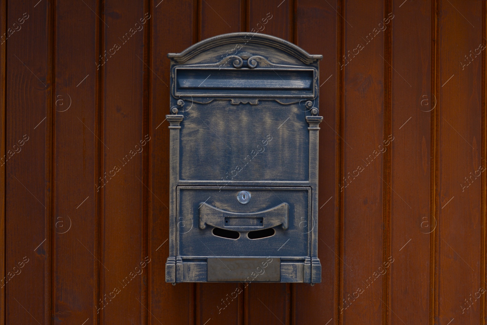 Photo of Metal letter box on wooden wall outdoors