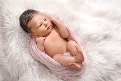 Photo of Cute newborn baby lying on fuzzy blanket, top view