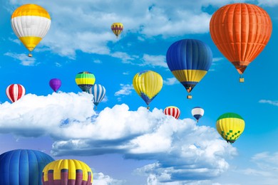 Many bright hot air balloons flying in sky