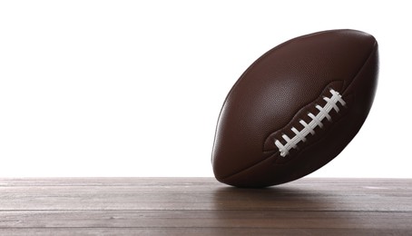 Photo of American football ball on wooden table against white background. Space for text