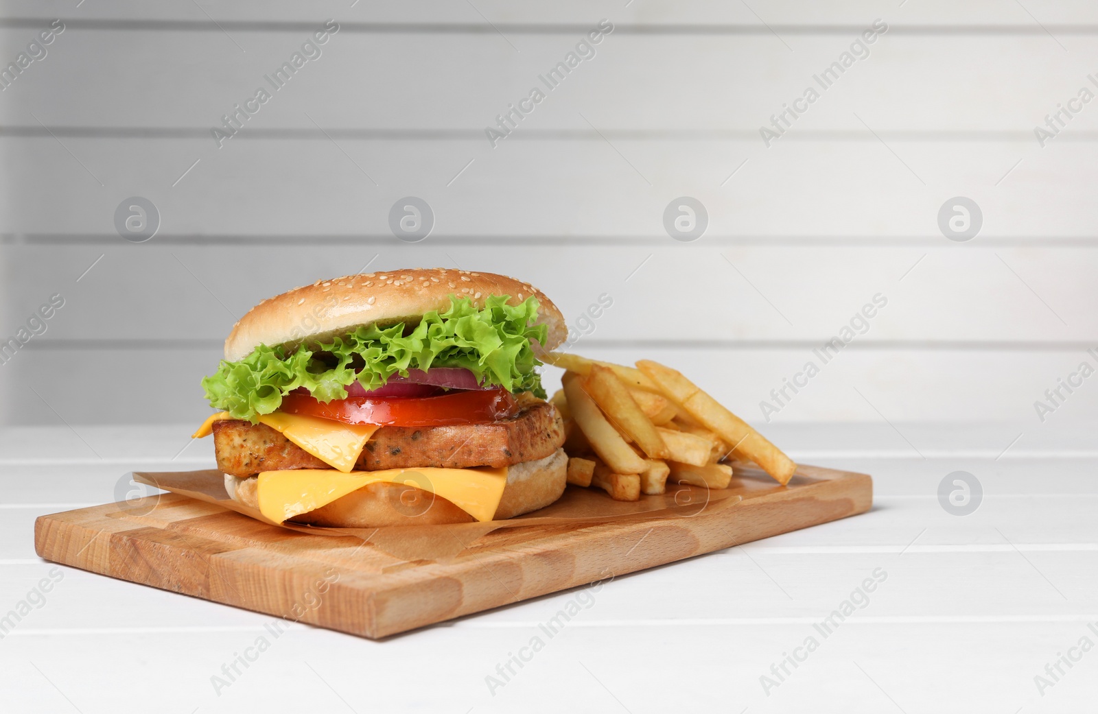 Photo of Delicious tofu burger served with french fries on white table. Space for text